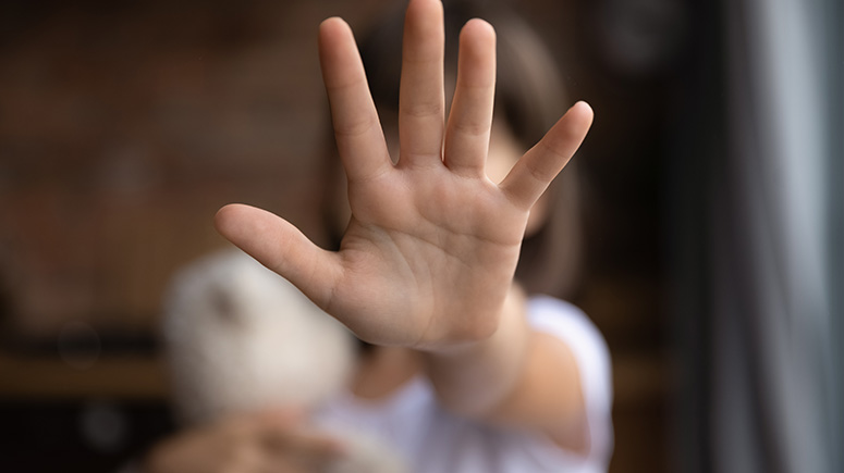 Blurred image of child with hand outstretched covering their face